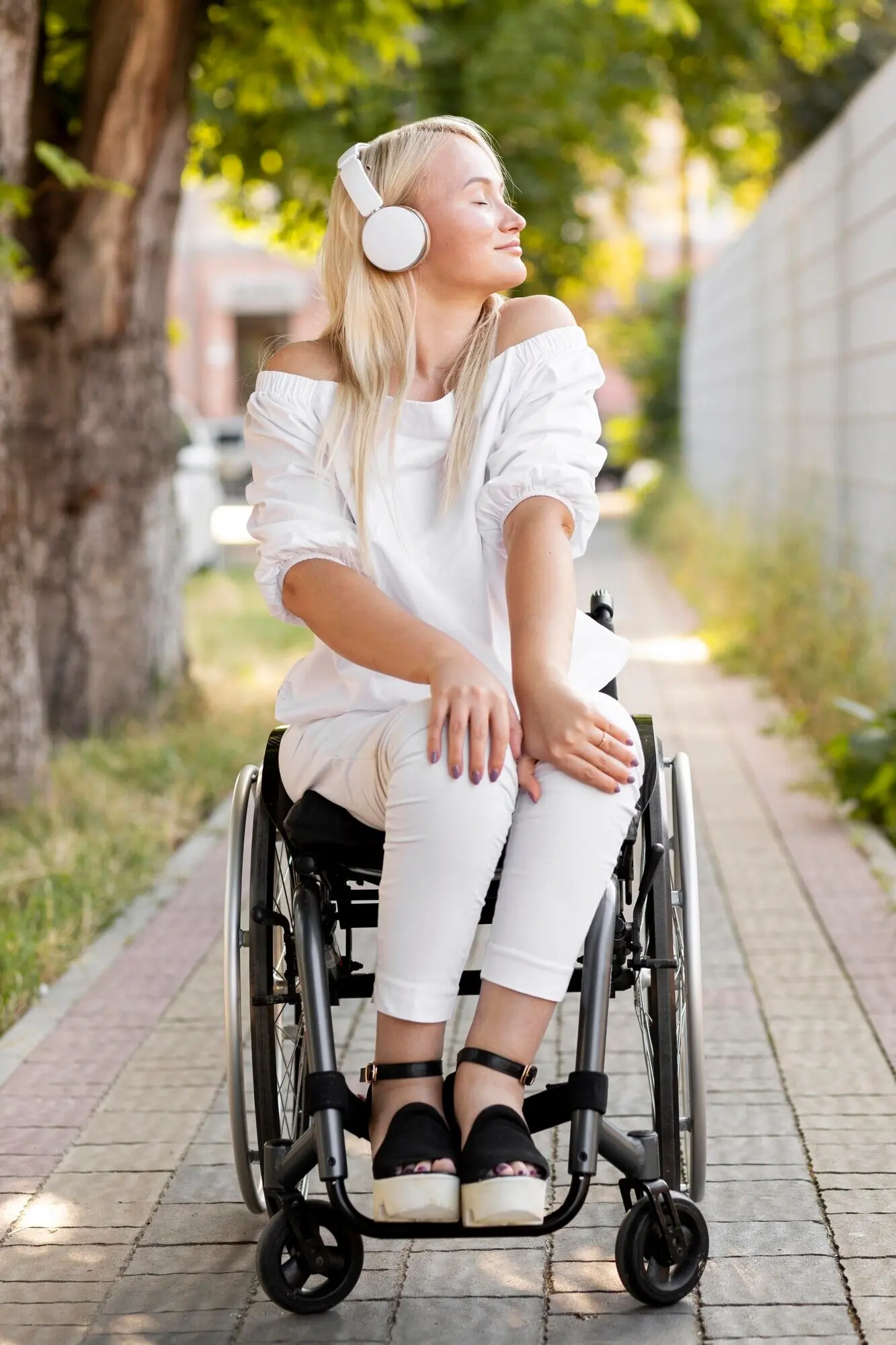A woman in a wheelchair wearing headphones